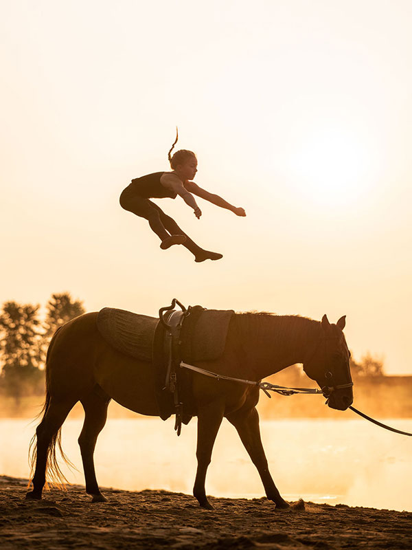 Girl vaulting at sunset beside a river. Nation Valley Ranch in Chesterville, Ontario